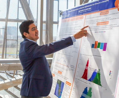 Graduate Student presenting a  research poster on agricultural policy